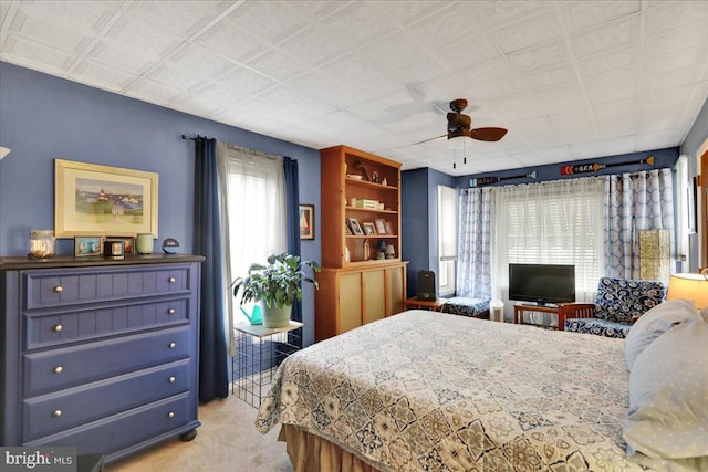 bedroom featuring light carpet and ceiling fan