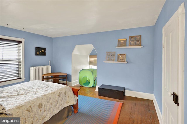 bedroom featuring dark hardwood / wood-style flooring and radiator