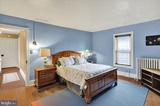 bedroom featuring radiator heating unit and dark hardwood / wood-style floors