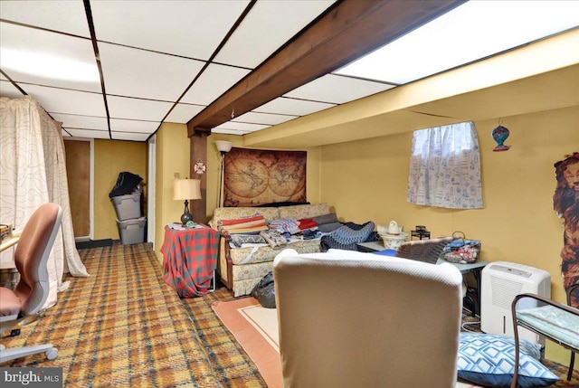 living room with a drop ceiling and carpet flooring