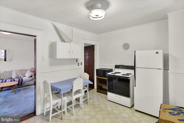 kitchen with crown molding, white cabinets, and white appliances