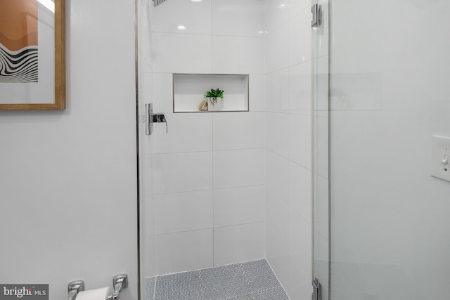 bathroom featuring a shower with door