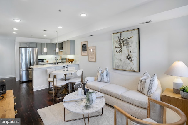 living room featuring sink and dark hardwood / wood-style flooring