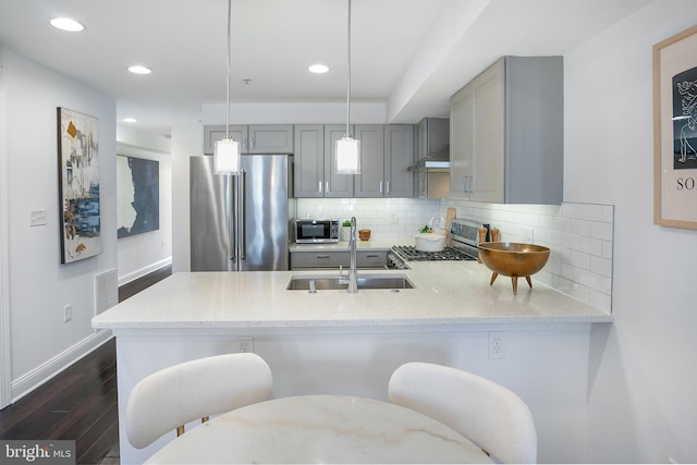 kitchen featuring gray cabinets, decorative light fixtures, decorative backsplash, kitchen peninsula, and stainless steel appliances