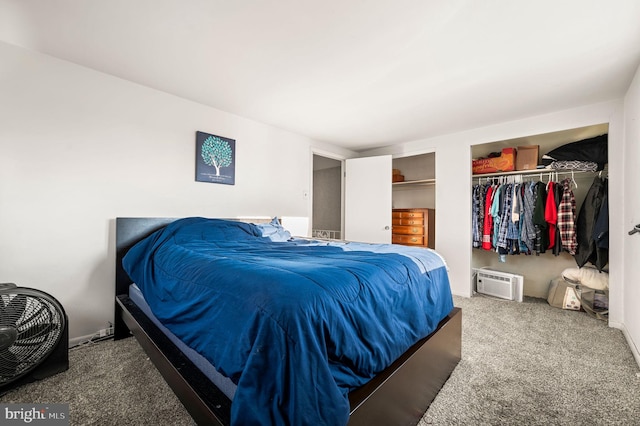 carpeted bedroom featuring a wall mounted air conditioner and two closets