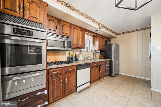 kitchen featuring tasteful backsplash, stainless steel appliances, sink, and light tile patterned floors