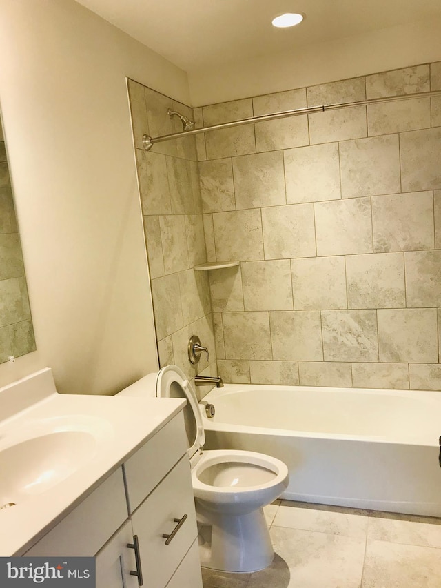 full bathroom featuring vanity, tiled shower / bath combo, and toilet