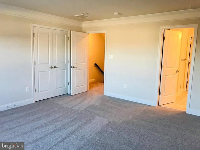 unfurnished bedroom with crown molding, a closet, and light carpet