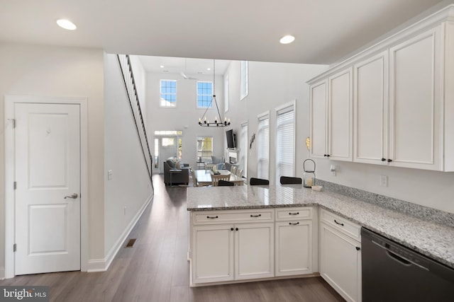 kitchen with white cabinetry, dishwasher, light hardwood / wood-style floors, and light stone countertops