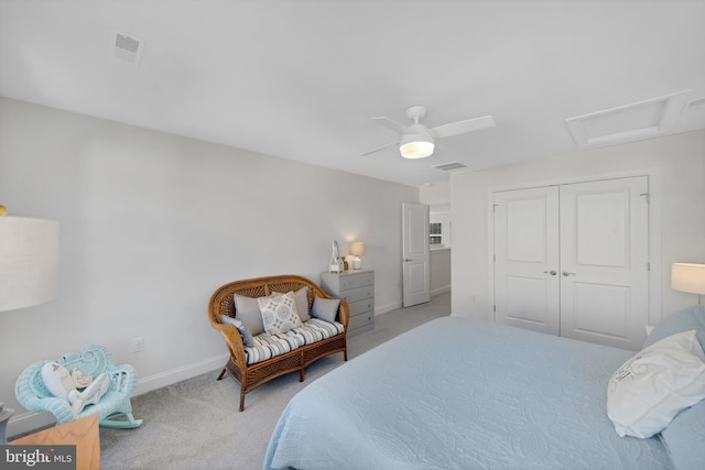 bedroom featuring light colored carpet, ceiling fan, and a closet