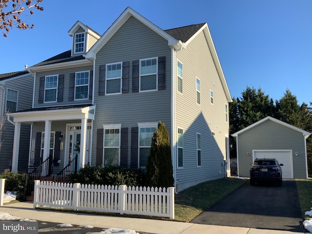 view of front of house featuring a garage, an outdoor structure, and covered porch