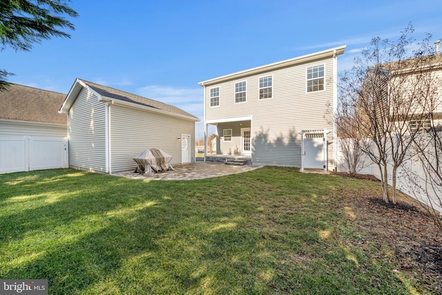 rear view of house featuring a patio area and a lawn