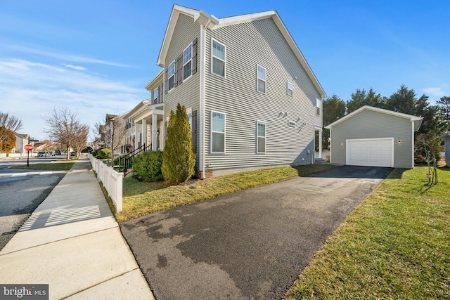 view of side of property with a garage, an outdoor structure, and a lawn