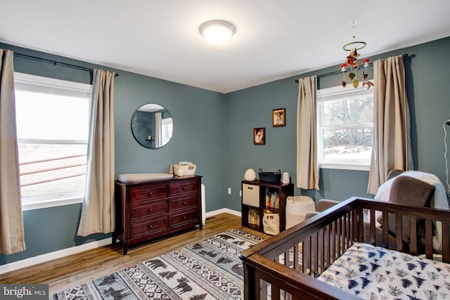 bedroom featuring hardwood / wood-style floors and a crib