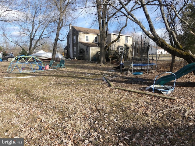 view of yard featuring a playground and a trampoline