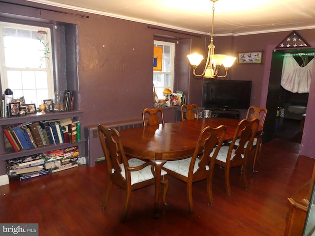 dining space with crown molding, hardwood / wood-style flooring, and a chandelier