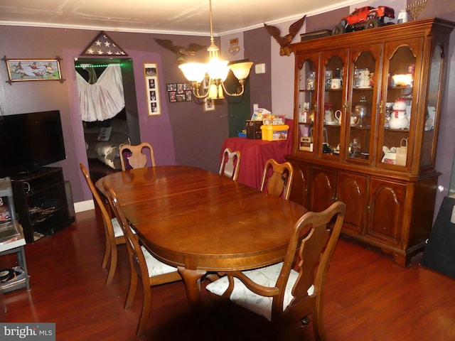 dining area featuring dark wood-type flooring, crown molding, and a notable chandelier