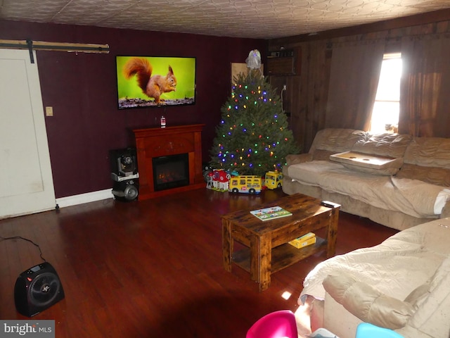 living room with a barn door and hardwood / wood-style floors