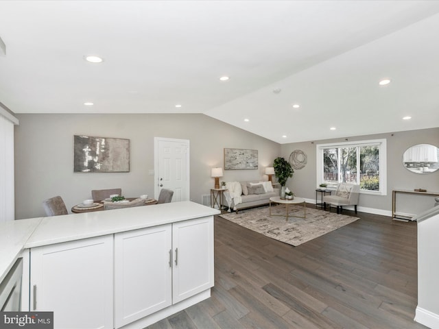 interior space featuring white cabinets, lofted ceiling, open floor plan, dark wood-style flooring, and light countertops