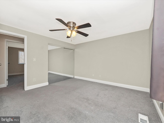 unfurnished bedroom featuring visible vents, baseboards, ceiling fan, carpet, and a closet