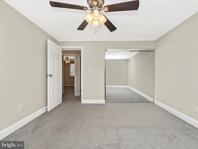 unfurnished bedroom with a closet, carpet, a ceiling fan, and baseboards