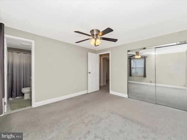 unfurnished bedroom with a closet, carpet flooring, ensuite bath, and baseboards