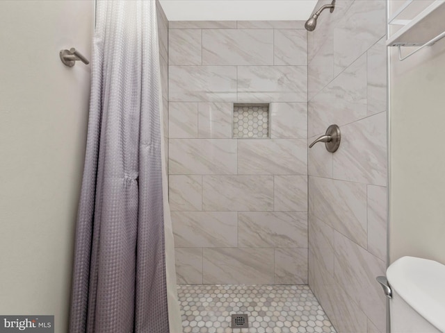 full bath featuring toilet and a tile shower