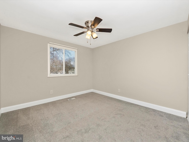 empty room featuring a ceiling fan, carpet, visible vents, and baseboards