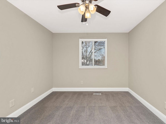 carpeted empty room with visible vents, baseboards, and a ceiling fan