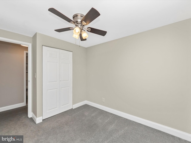 unfurnished bedroom with ceiling fan, baseboards, dark carpet, and a closet