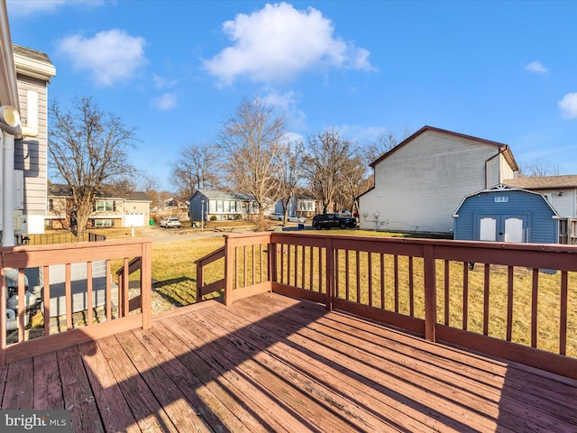 deck with an outbuilding, a yard, a storage unit, and a residential view