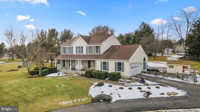 view of front facade featuring a porch, a garage, and a front lawn