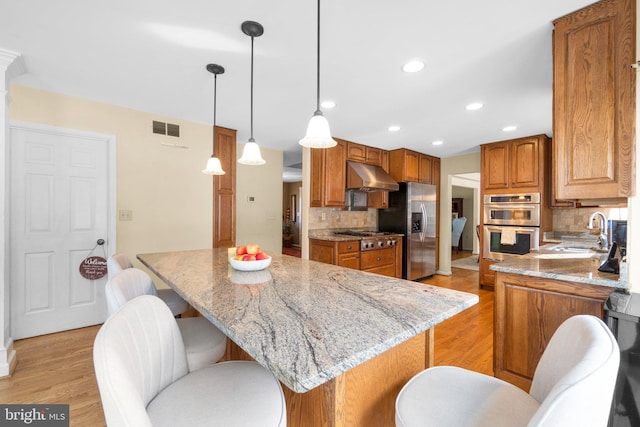 kitchen featuring a center island, appliances with stainless steel finishes, sink, and pendant lighting