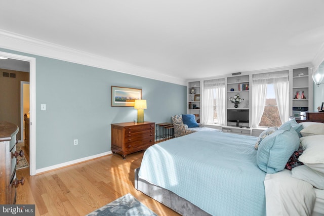 bedroom featuring ornamental molding and light hardwood / wood-style flooring