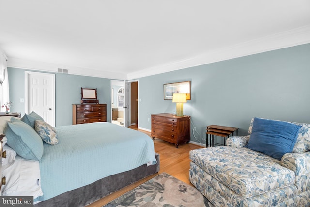 bedroom with ornamental molding and hardwood / wood-style floors