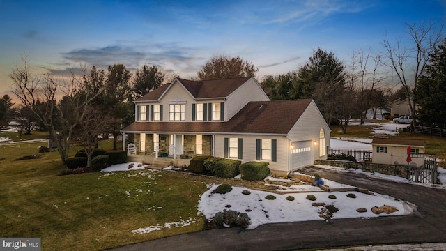 view of front of property with a garage and a lawn