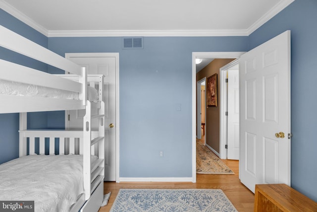 bedroom featuring wood-type flooring and ornamental molding