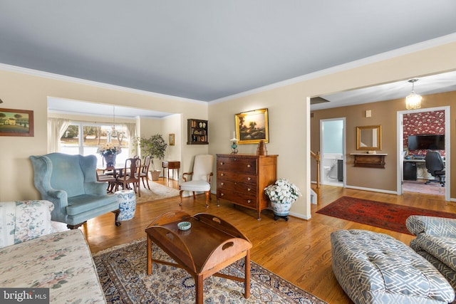 living room featuring ornamental molding, hardwood / wood-style floors, and a notable chandelier