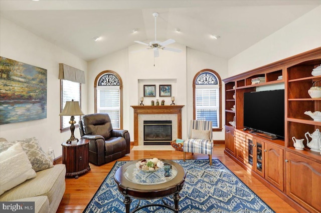 living room with lofted ceiling, ceiling fan, and light hardwood / wood-style flooring