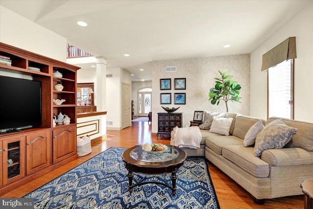 living room featuring decorative columns and light wood-type flooring