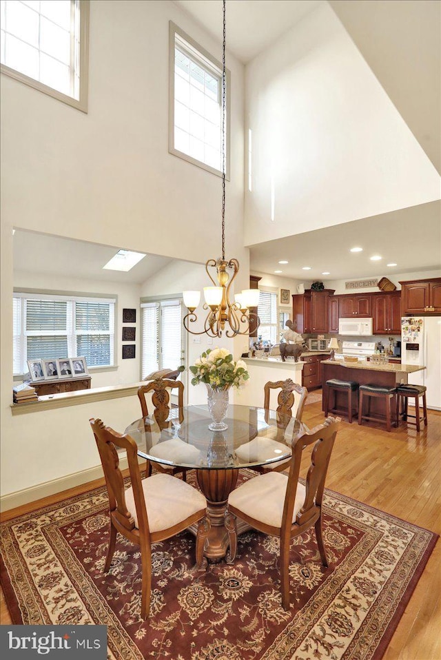 dining space with a notable chandelier and light hardwood / wood-style flooring