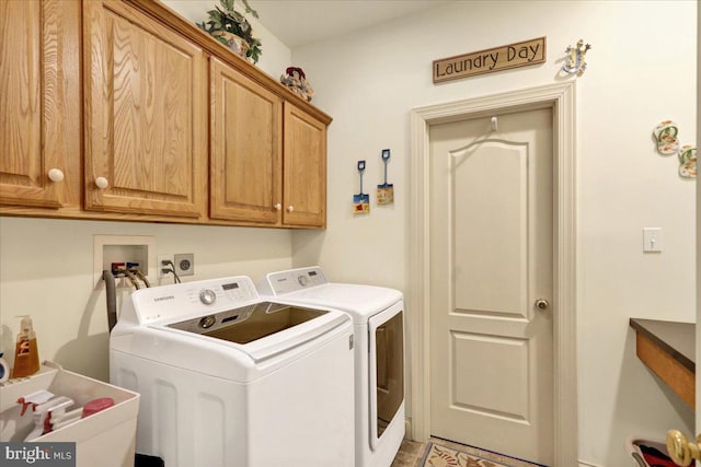 washroom with washer and dryer and cabinets