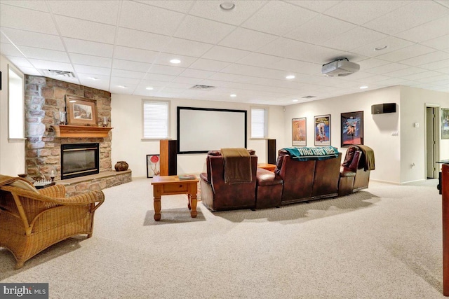 home theater featuring a paneled ceiling, light carpet, and a fireplace