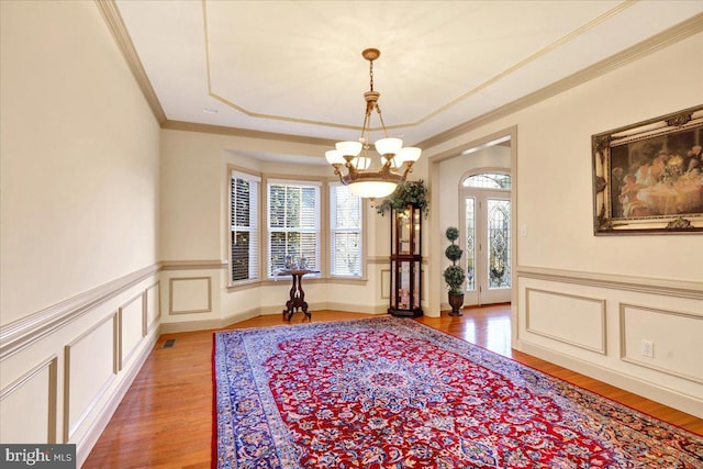 interior space featuring ornamental molding, plenty of natural light, a chandelier, and hardwood / wood-style floors