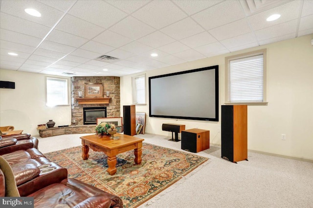 home theater with a fireplace, light carpet, and a drop ceiling