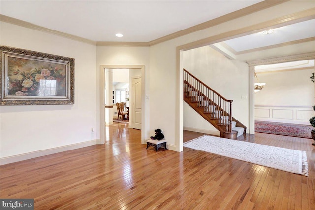 entrance foyer featuring crown molding, hardwood / wood-style floors, and a notable chandelier