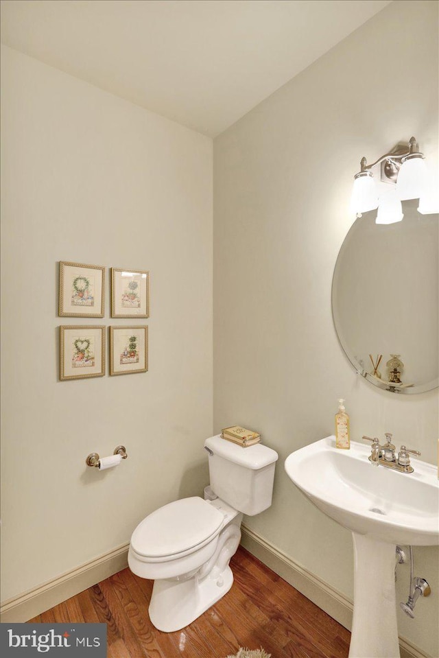 bathroom with hardwood / wood-style floors, sink, and toilet