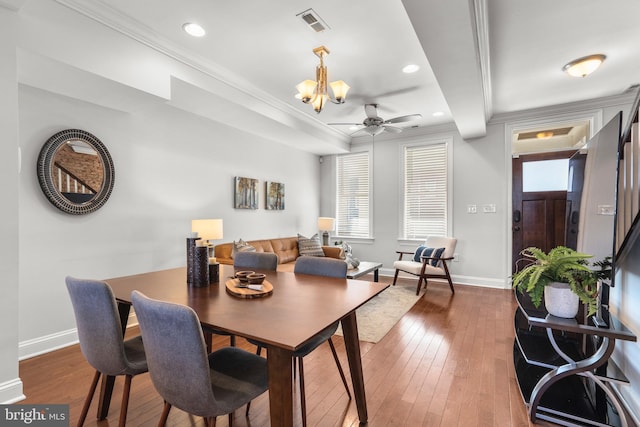 dining space featuring crown molding, ceiling fan with notable chandelier, and dark hardwood / wood-style floors