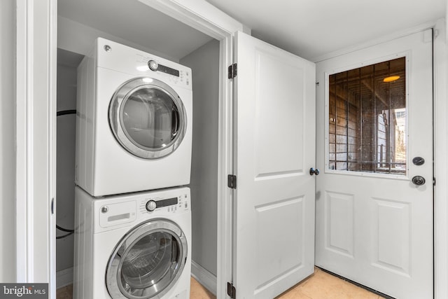 washroom featuring stacked washer / dryer and light tile patterned floors