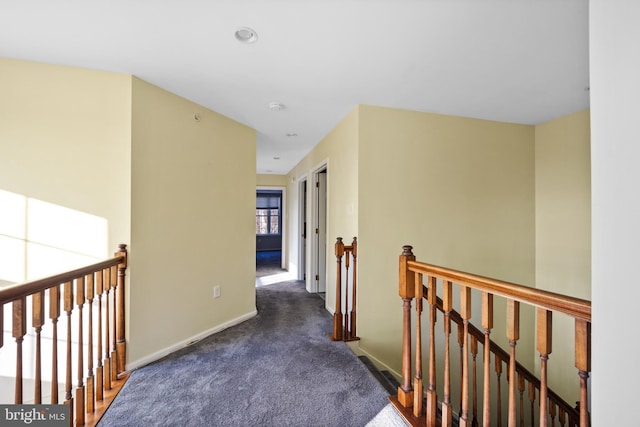 hall with dark colored carpet